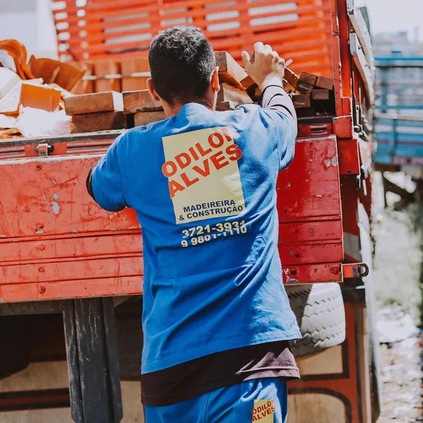Funcionário da Odilon Alves organizando madeiras na carroceria do caminhão