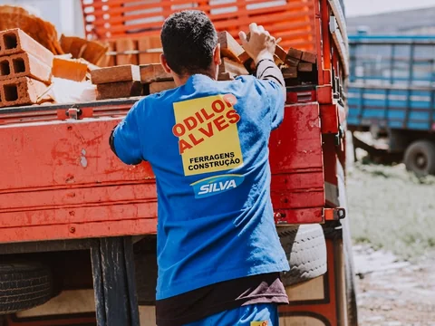 Colaborador carregando madeiras no caminhão